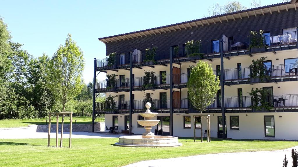 a building with a fountain in front of it at Waldhotel Rainau in Ellwangen