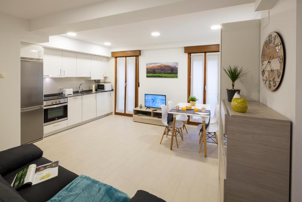 Una cocina y una sala de estar con mesa y sillas. en Ciudad de Orduña, en Orduña