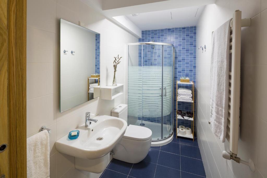 Un baño con lavabo, inodoro y espejo. en Ciudad de Orduña, en Orduña