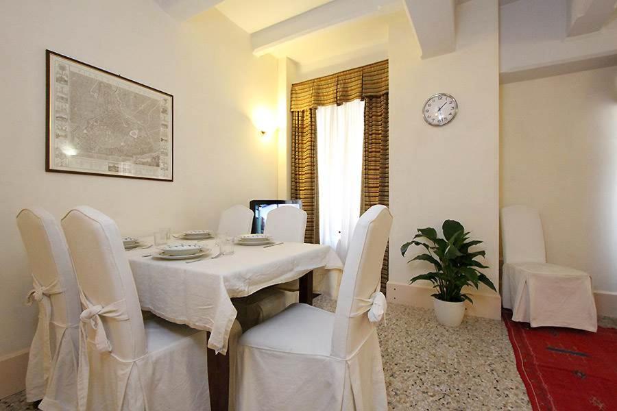 ein Esszimmer mit einem Tisch und weißen Stühlen in der Unterkunft Camilla apartment in Venice-Molino in Venedig