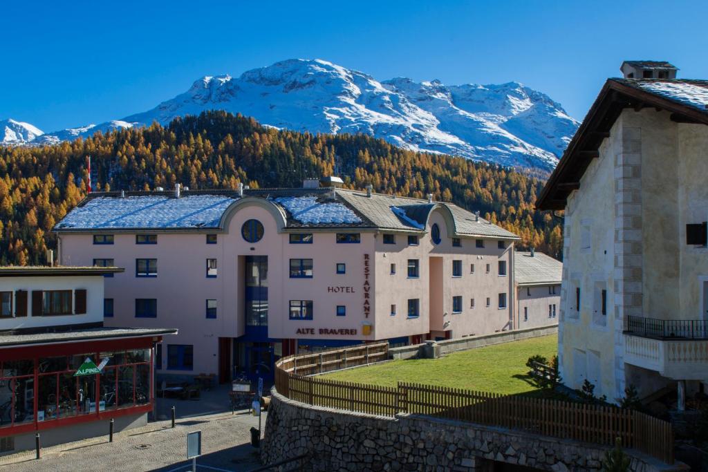 um grupo de edifícios com montanhas ao fundo em Hotel Restaurant Alte Brauerei em Celerina