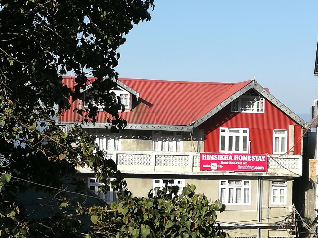 a red building with a red roof at Himshikha Homestay in Darjeeling