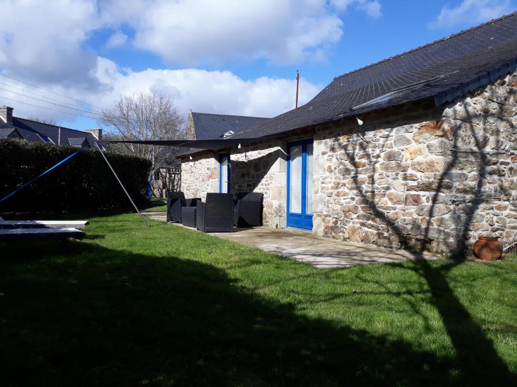 une maison en pierre avec des portes bleues et une cour dans l'établissement studio en campagne, à La Chapelle-Neuve