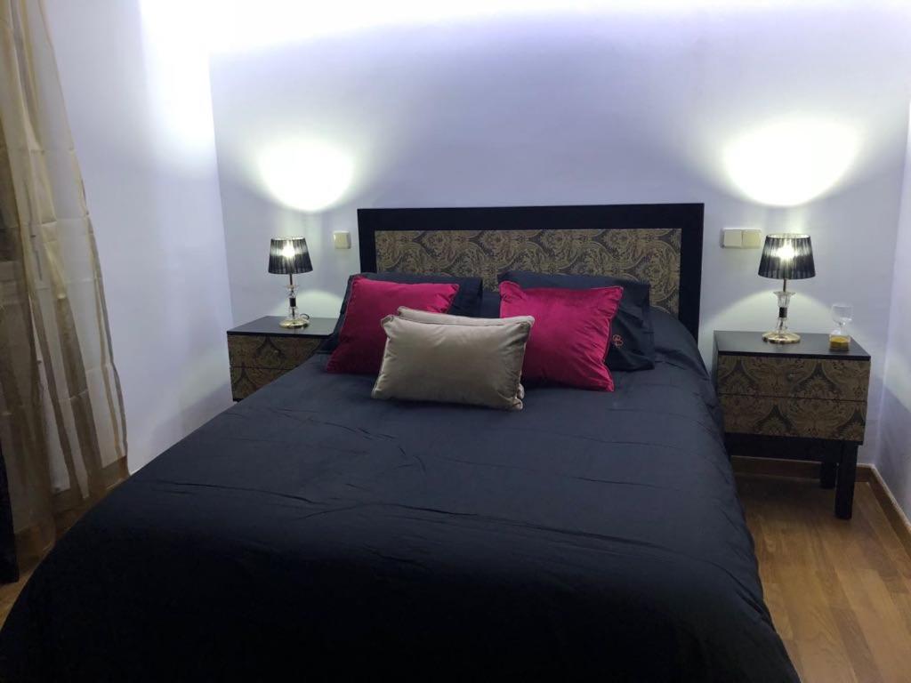 アレーナス・デ・サン・ペドロにあるApartamentos Las Ferreriasのベッドルーム1室(大型ベッド1台、ランプ2つ付)