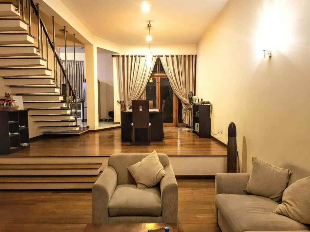 a living room with two couches and a staircase at Occazia Residence in Colombo