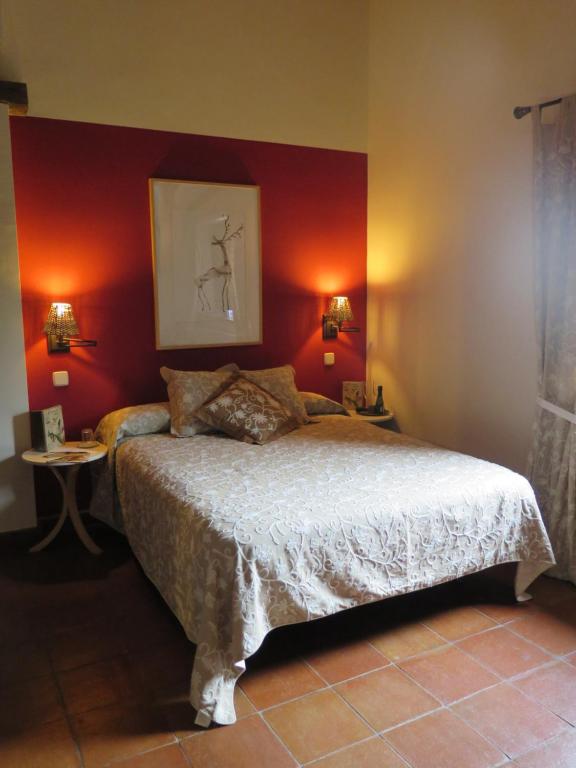 Schlafzimmer mit einem Bett mit roten Wänden in der Unterkunft La Casona de Requijada in Requijada