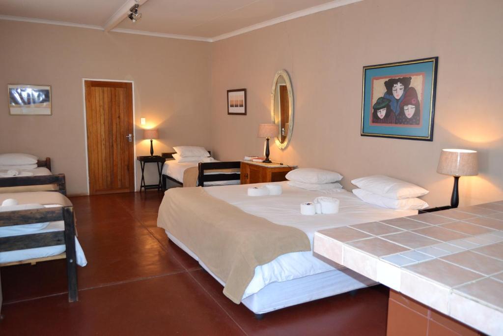 a hotel room with two beds and a mirror at Savanna Guest Farm in Grünau