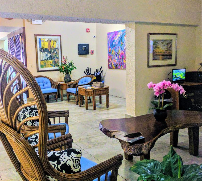 una sala de estar con sillas y una mesa con flores. en Canario Lagoon Hotel, en San Juan