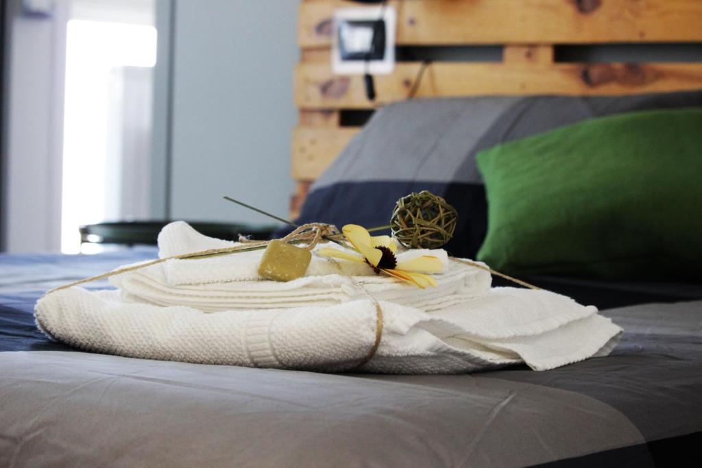 una pila de toallas y plátanos en una cama en Alloggio Lentini, en Carlentini