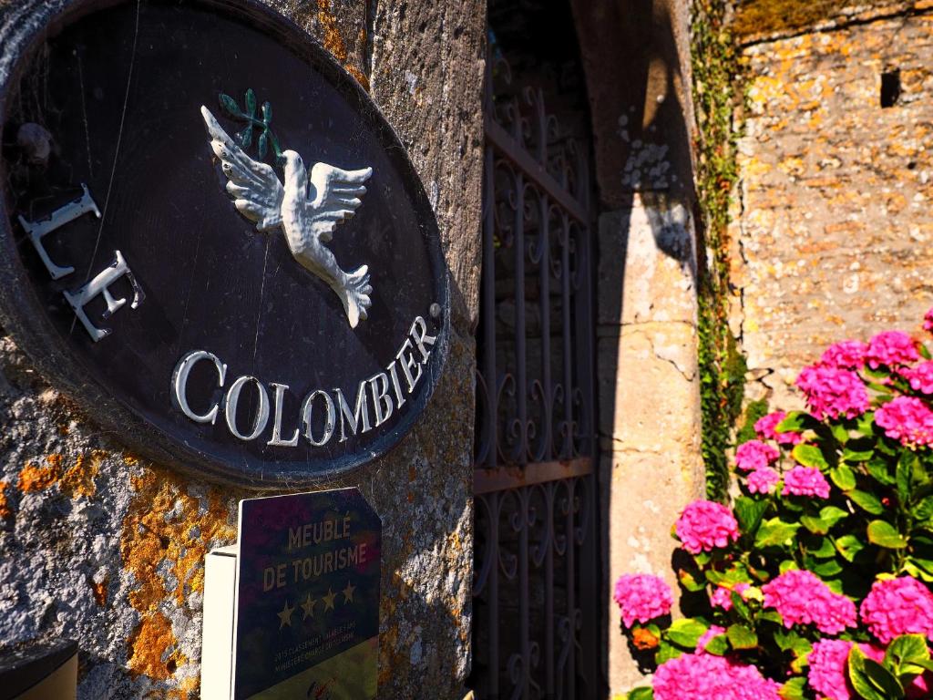 un panneau sur le côté d'un bâtiment avec des fleurs dans l'établissement Chateau Le Colombier, à Brévands