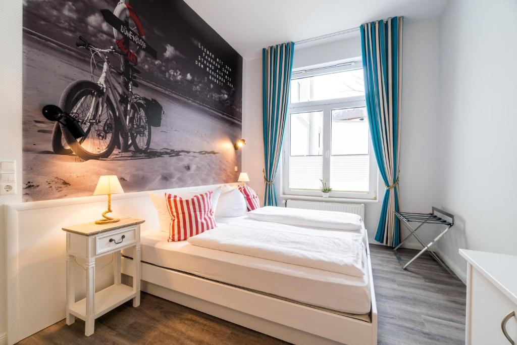 een slaapkamer met een bed met een fiets aan de muur bij Ria‘s Beachhouse in Borkum