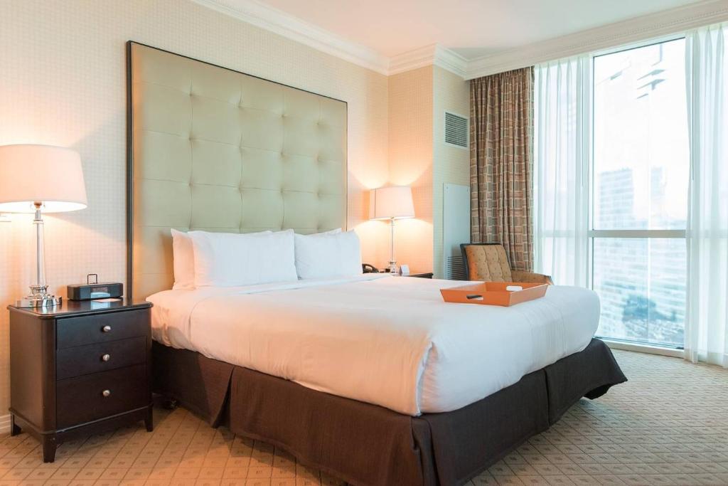 uma cama grande num quarto de hotel com uma janela grande em True 1BR Balcony Suite with Strip View at MGM Signature em Las Vegas