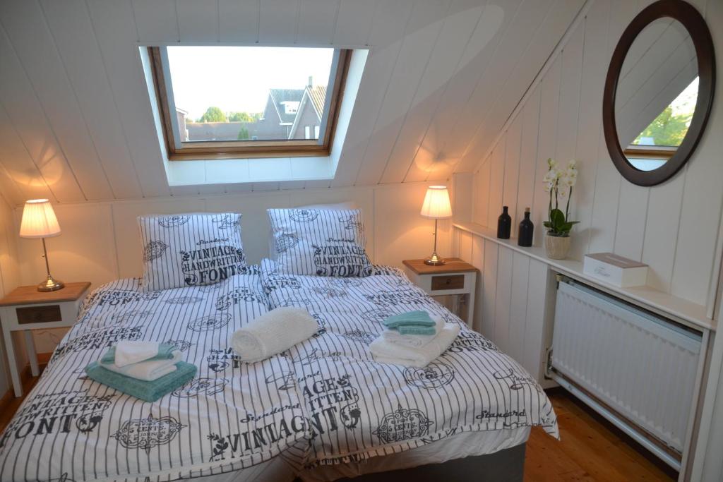 Vierlingsbeek的住宿－Herberg Thijssen，一间卧室配有一张大床、枕头和镜子