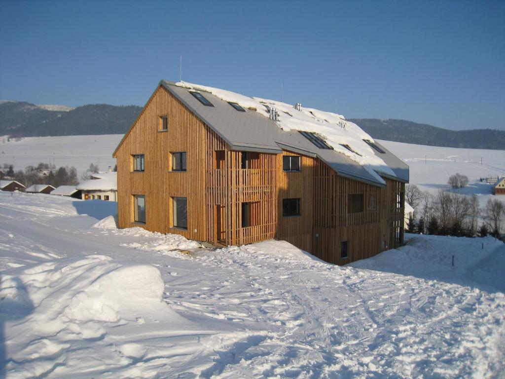 un granero de madera cubierto de nieve en Apartmán u Kamila, en Dolní Morava