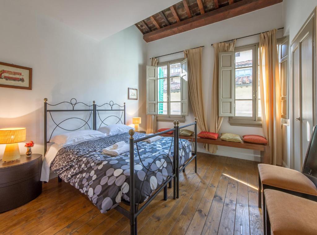 a bedroom with a bed and two windows at Mamo Florence - Uffizi Gallery Rooftop Apartment in Florence