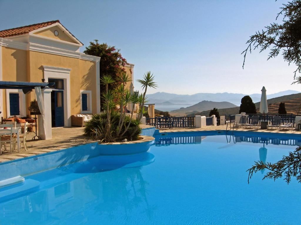 a villa with a swimming pool with mountains in the background at Lefkes Village in Lefkes