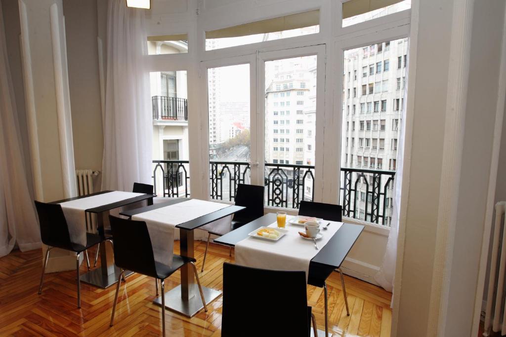 a dining room with tables and chairs and a large window at Rincón de Gran Vía in Madrid