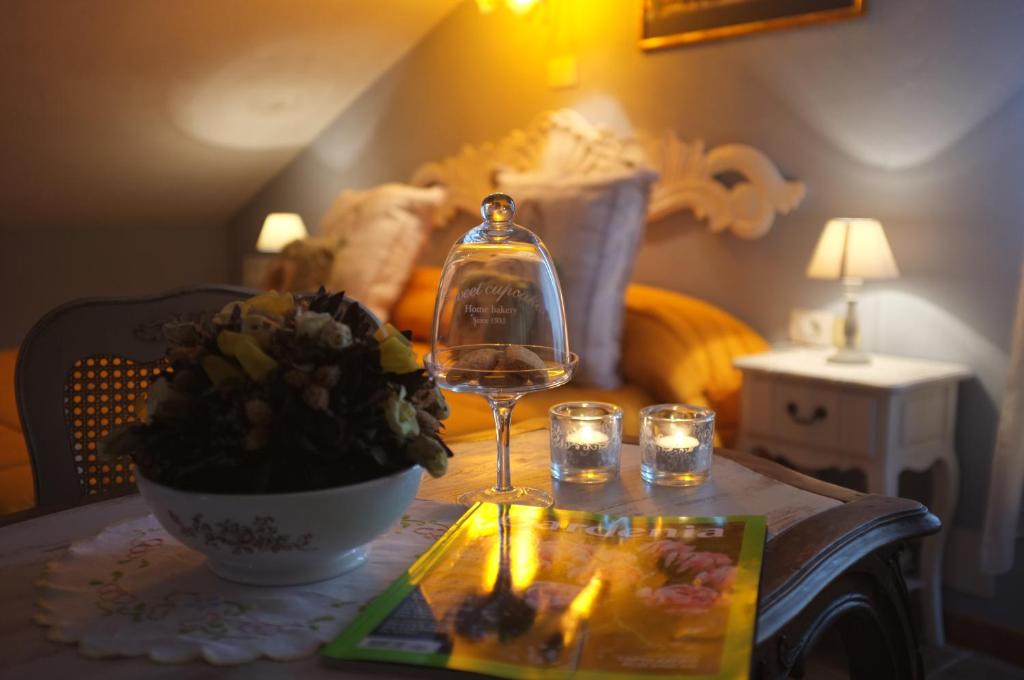 un bicchiere di vino seduto su un tavolo con una pianta di B&B The Roses Garden a Millesimo
