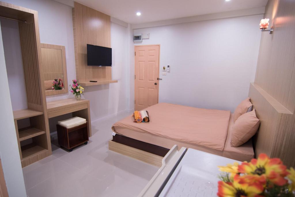 Cette petite chambre comprend un petit lit et un bureau. dans l'établissement TN Thanyawit, à Nakhon Ratchasima