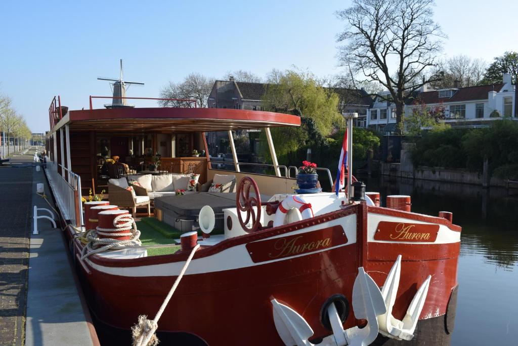 un barco atracado en el agua con un restaurante. en Aurora en Schiedam