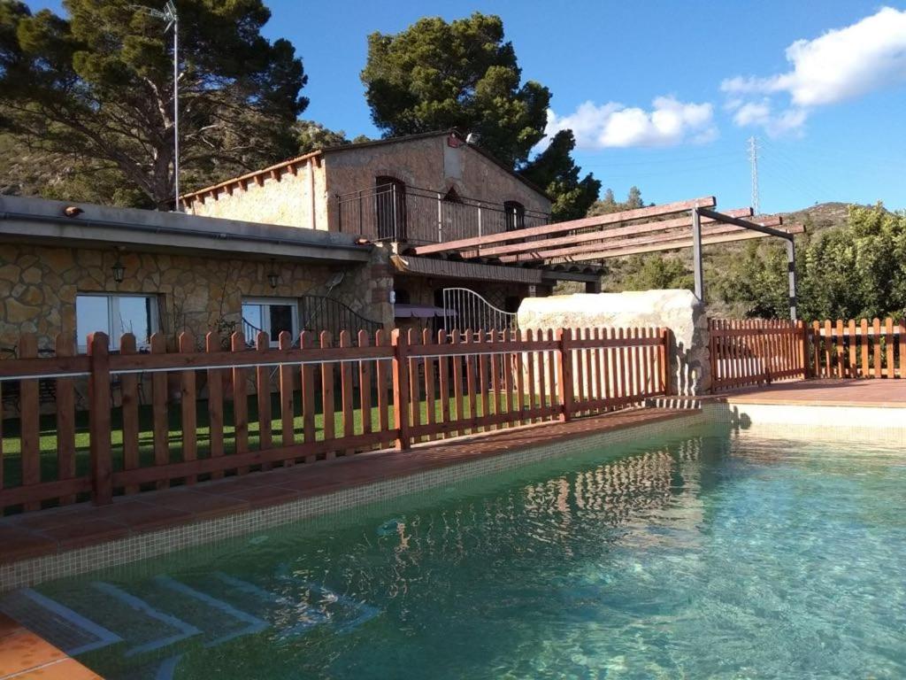 a wooden fence next to a pool of water at Can Sabate in Hospitalet de l'Infant