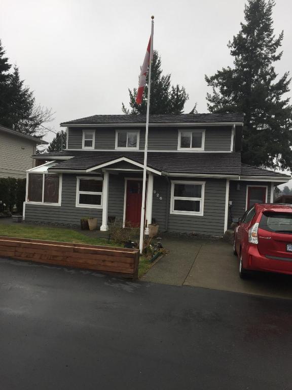 a house with a red car parked in front of it at Money Pennies Bed and Breakfast in Campbell River