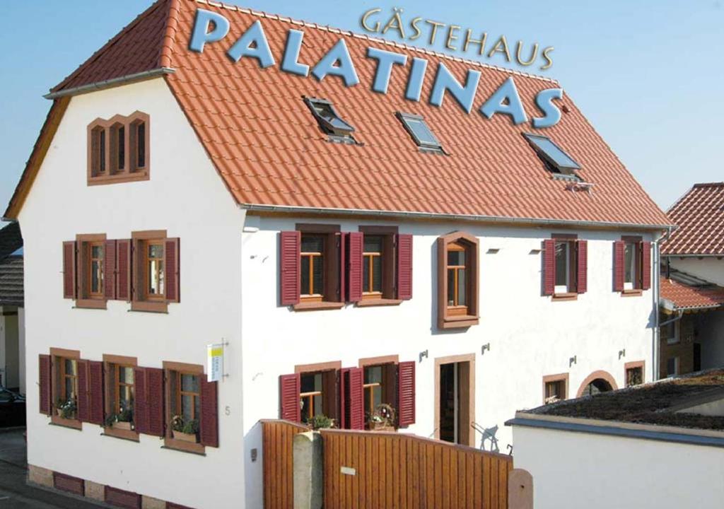 ein weißes Gebäude mit einem Schild darüber in der Unterkunft Gästehaus PALATINAS in Böchingen
