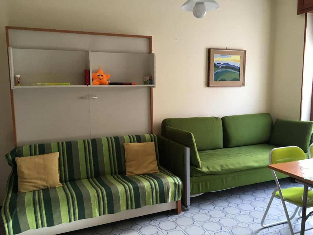 a living room with a green couch and a table at Appartamento in Riviera Ligure in Borghetto Santo Spirito