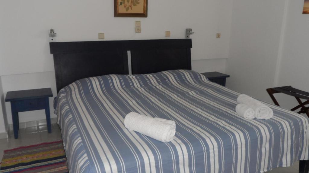 a bed with two rolled towels on top of it at Villa Giorgos in Kefalos