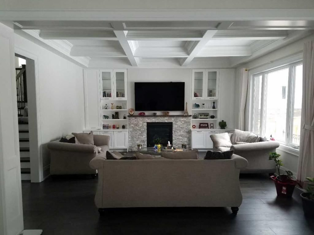 uma sala de estar com sofás e uma televisão de ecrã plano em Comfortable private space em Pickering