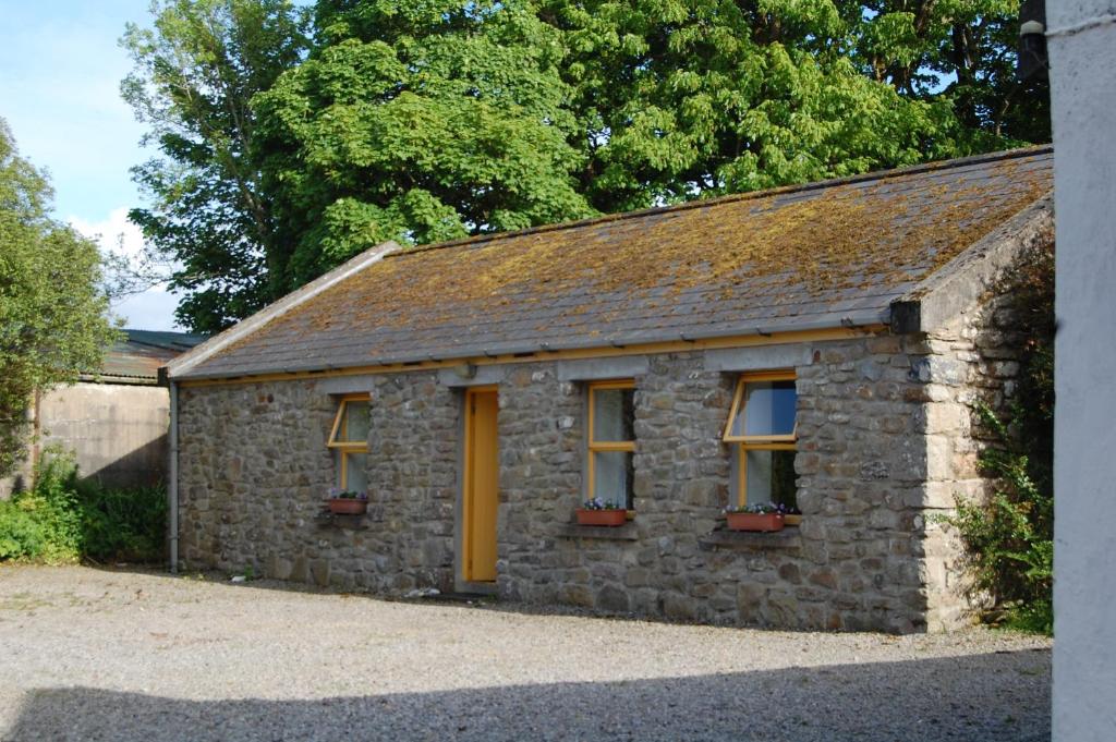 a stone building with yellow doors and windows at Ardtarmon Garden Cottage in Sligo