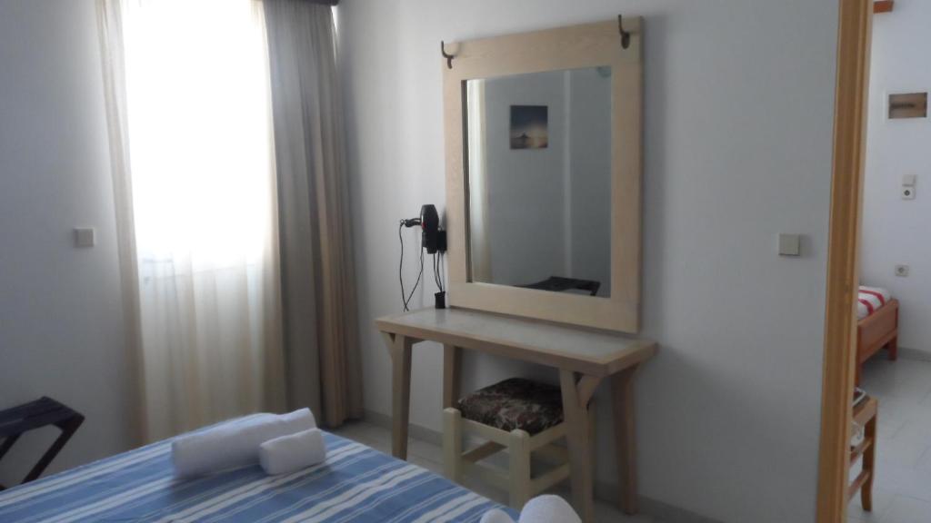 a bedroom with a bed and a mirror on a wall at Villa Giorgos in Kefalos
