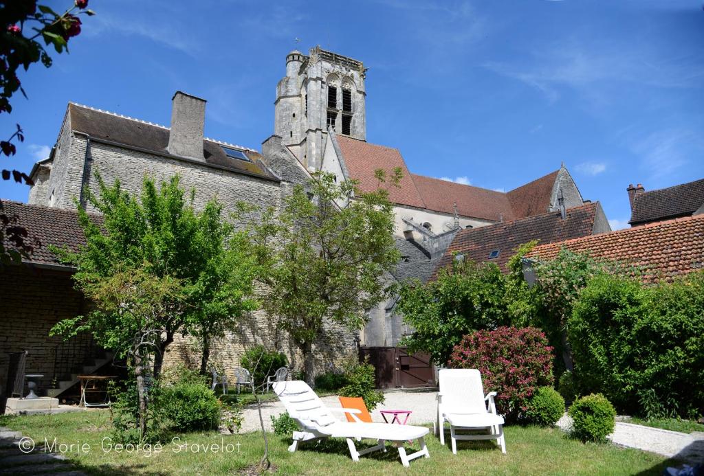 um grupo de cadeiras sentadas em frente a uma igreja em La Victoire de Noyers em Noyers-sur-Serein