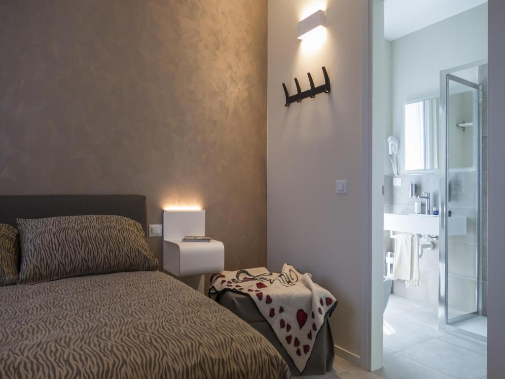a small bedroom with a bed and a bathroom at Hotel Buena Onda in Peschiera del Garda