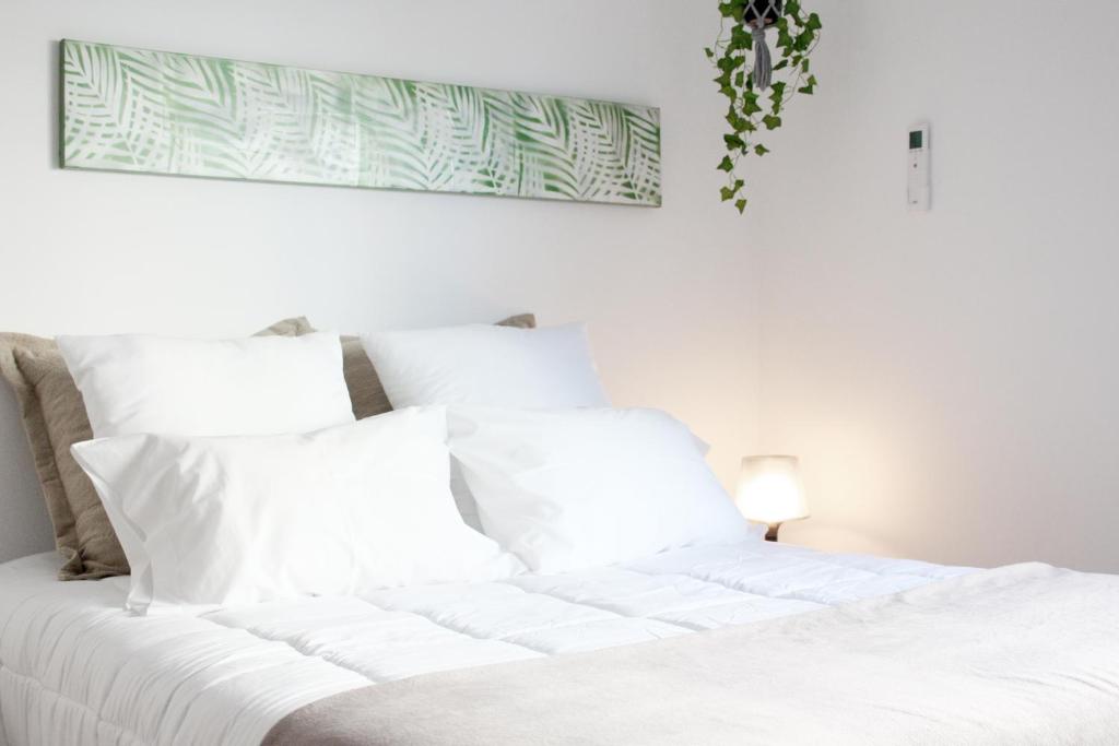 
a white bed with white pillows and pillows at Easy4Stay in Portimão
