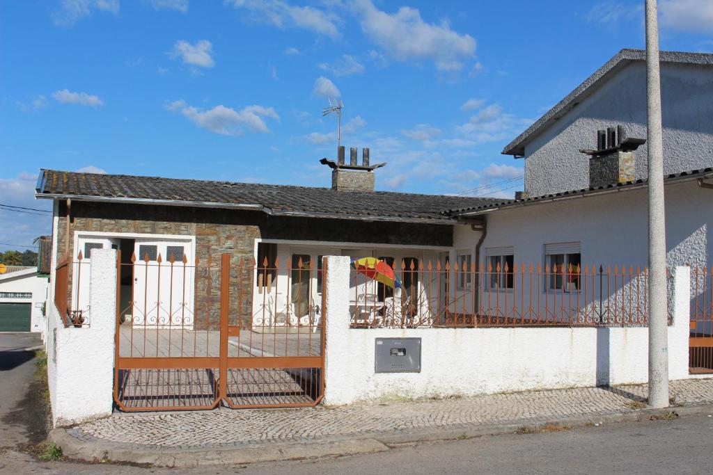 a white house with a fence and a building at Cozy Summer House by the Beach in Ovar