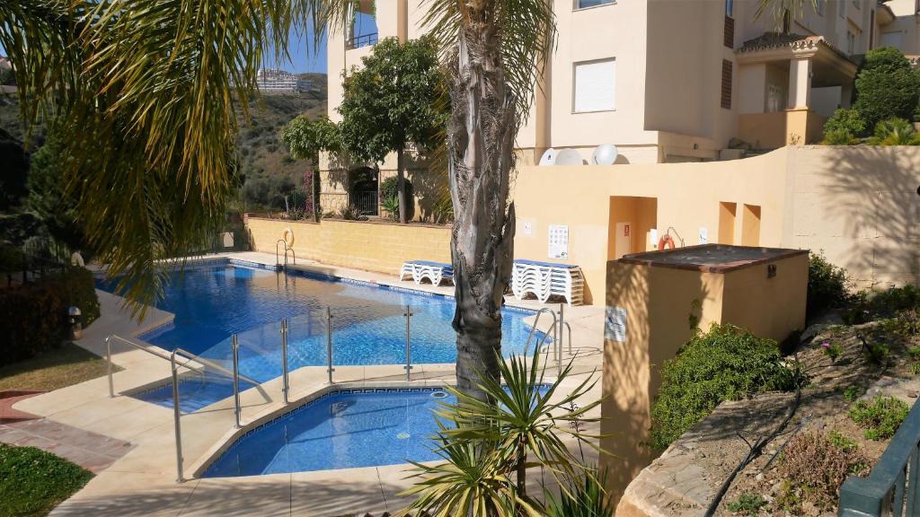 a swimming pool in front of a building at Appartement Hillside Suite in Mijas