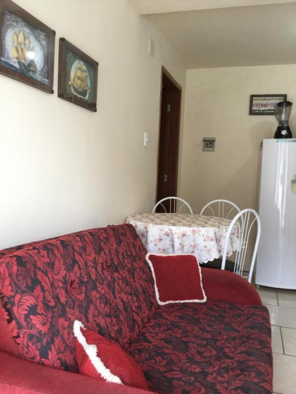 sala de estar con sofá rojo y mesa en Ap aconchegante Floripa, en Florianópolis