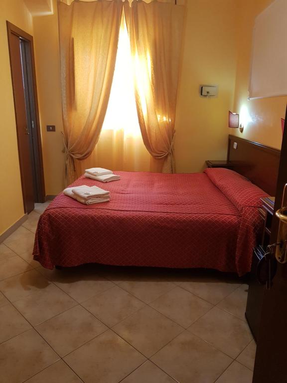 a bedroom with a red bed with a window at B&B Rudy in Rome