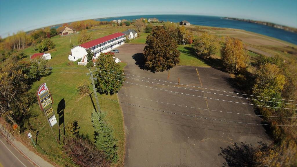 une vue aérienne sur une ferme avec un bâtiment et une route dans l'établissement Bouctouche Bay Inn, à Bouctouche