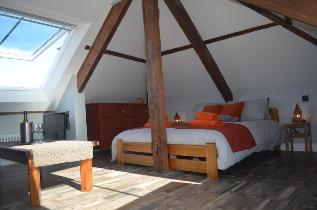 una camera da letto con un grande letto e travi in legno di Appledore Factory ad Appledore