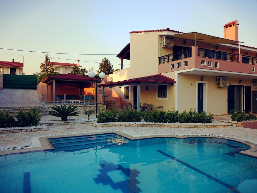 a house with a swimming pool in front of a house at Terra Relaxa in Loutraki