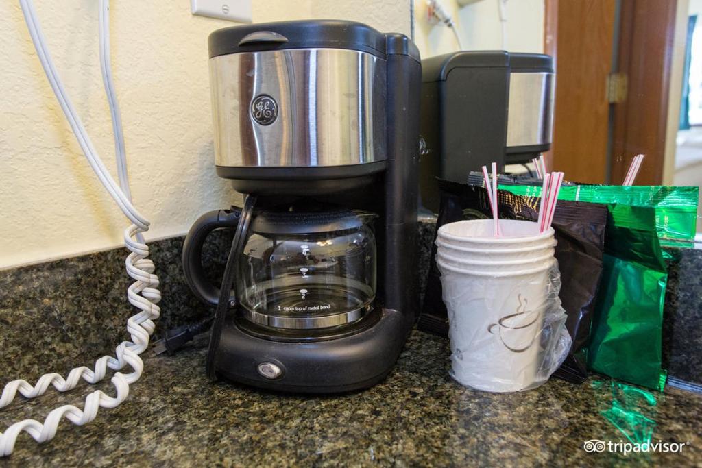 a coffee maker sitting on a counter next to a cup at Seven Gables Inn in Branson