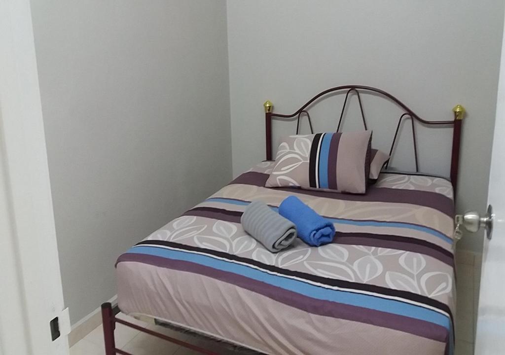 ein Schlafzimmer mit einem Bett mit zwei Kissen in der Unterkunft Taman Tanjung Minyak Homestay in Malakka
