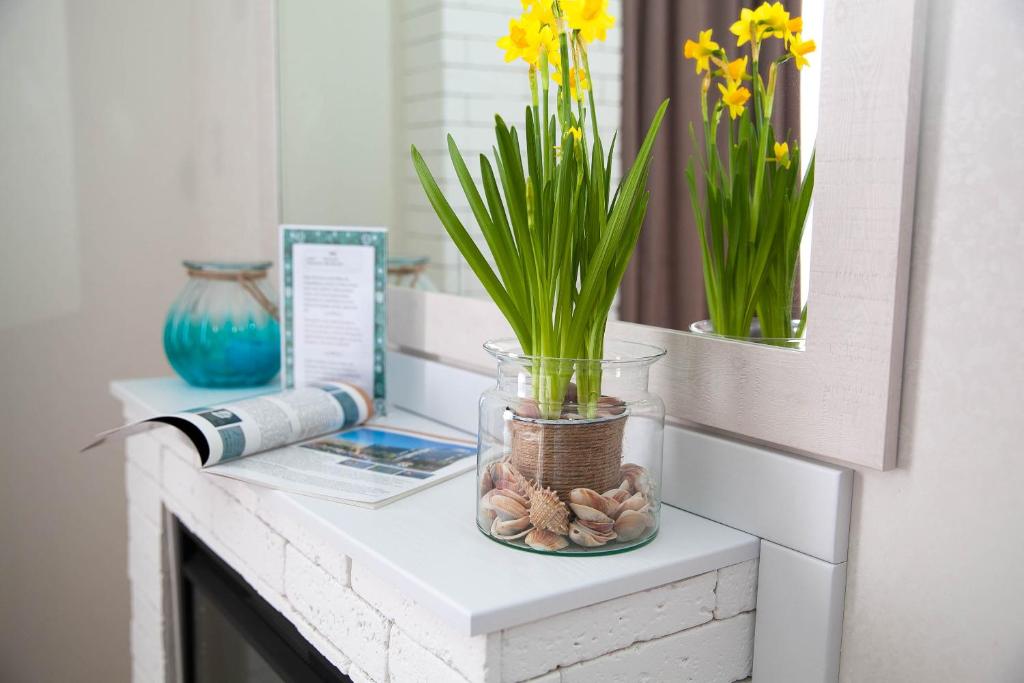 a bathroom counter with a vase with flowers and rocks at Rent of Apartments in Kharkiv in Kharkiv