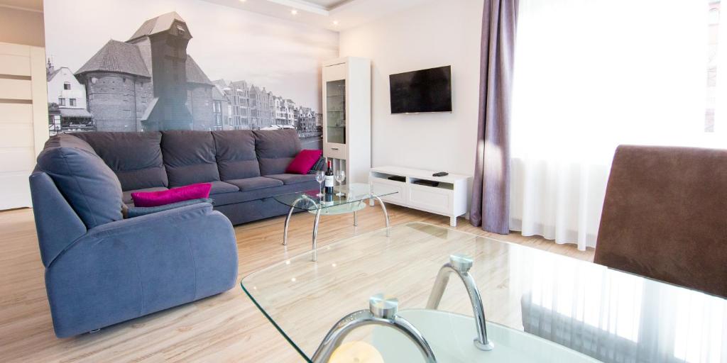 un soggiorno con divano blu e TV di Apartment Milena a Danzica