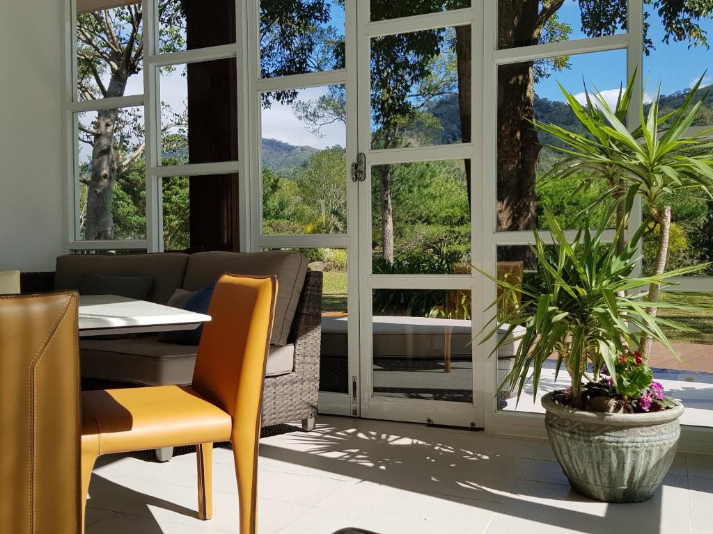 a dining room with a table and chairs and windows at Around The Tree Manor in Shitan