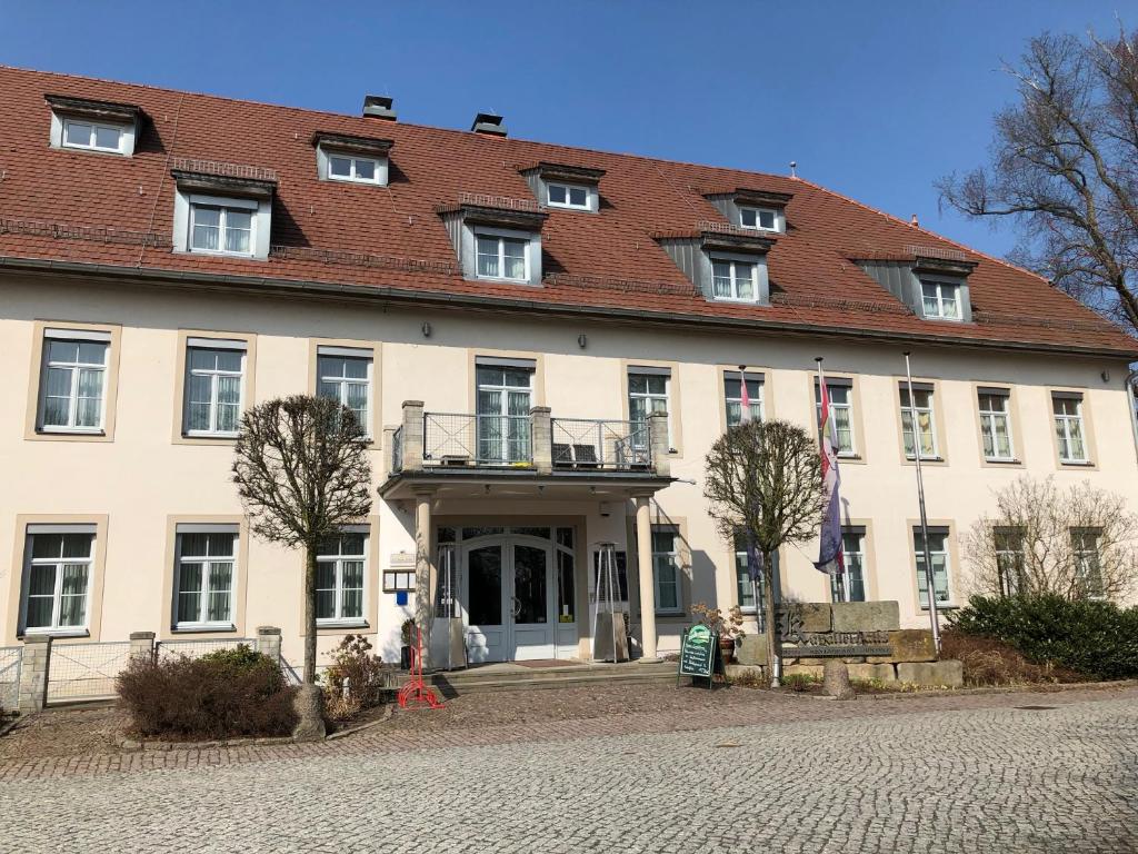 ein großes weißes Gebäude mit rotem Dach in der Unterkunft Hotel im Kavalierhaus in Machern