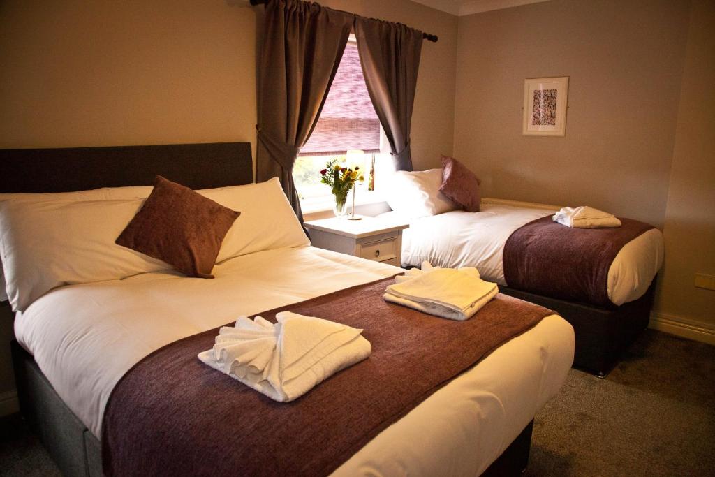 Habitación de hotel con 2 camas y ventana en Rowton Poplars Hotel, en Chester