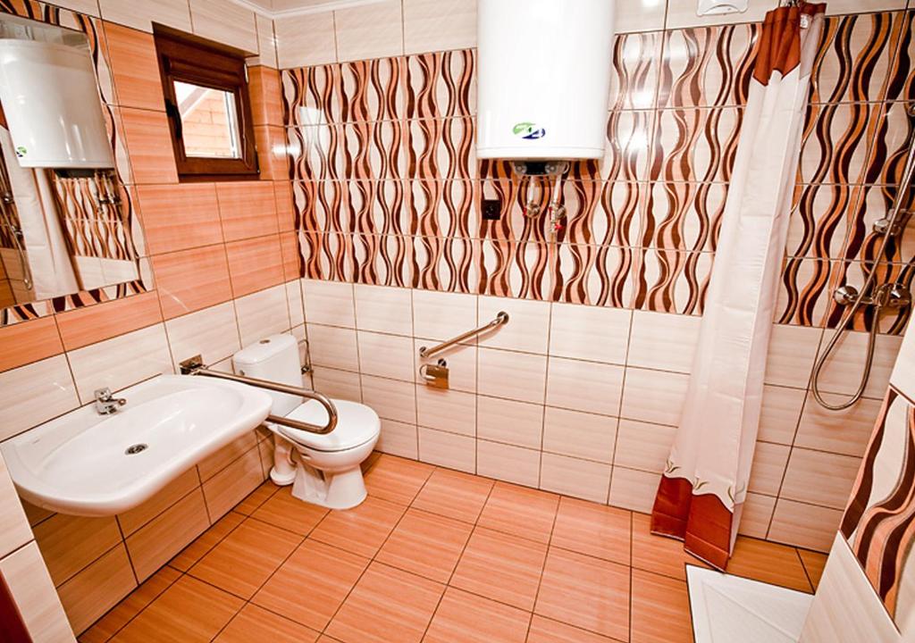 łazienka z toaletą i umywalką w obiekcie Kakadu domki letniskowe Niechorze w mieście Niechorze